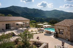 a house with a swimming pool and mountains in the background at villa du Passeron in Chambonas