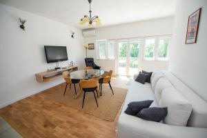 a living room with a white couch and a table at Villa Kosor Spring in Blagaj