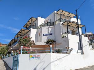 a white building with a fence in front of it at Kalliopi Studios - Apartments in Kato Daratso