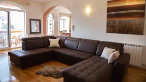 ein Wohnzimmer mit einem braunen Ledersofa in der Unterkunft Booking Zaton Villa Martinova holiday house with swimming pool in Zaton