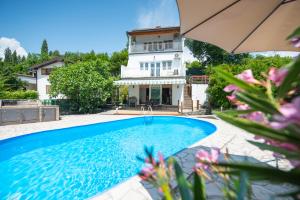a villa with a swimming pool in front of a house at Villa Kosor Spring in Blagaj