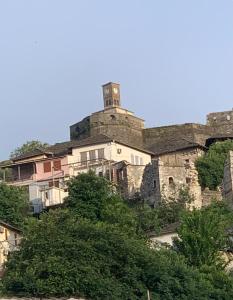 un edificio con una torre de reloj en la cima de una colina en Christina's house with 2 bedrooms and free parking, en Gjirokastra