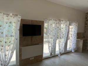 a living room with curtains and a tv and a window at Villa Jasmine - Cannes in Cannes