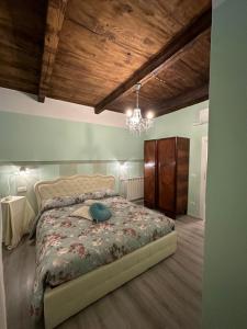 a bedroom with a bed and a chandelier at ANTICA DIMORA DEL BORGO Luxury TUSCANY in Bibbiena