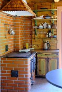 eine Küche mit Ziegelwand und Herd in der Unterkunft Saunahouse Rae Vallas in Seli