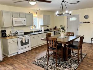 a kitchen with white cabinets and a table and chairs at Denali National Park 2 King Bedroom Hideaway with Amazing Views in Healy