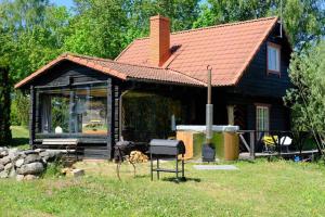 eine Blockhütte mit einem Grill davor in der Unterkunft Saunahouse Rae Vallas in Seli