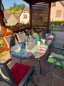 einen Tisch und Stühle auf einer Terrasse in der Unterkunft Chez Yolande in Nothalten
