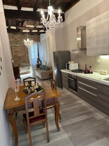 a kitchen with a wooden table and a dining room at ANTICA DIMORA DEL BORGO Luxury TUSCANY in Bibbiena