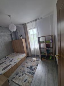 a bedroom with a bed and a window and a rug at Spacious&modern 4 rooms apartment in Târgu-Mureş