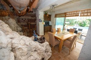 a dining room with a table and a stone wall at Villa Kosor Spring in Blagaj
