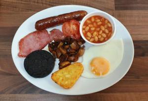 a plate of breakfast food with sausage beans beans and a egg at St Michael's Boutique Guest House, North Bay, Scarborough with free parking and fast wi-fi in Scarborough