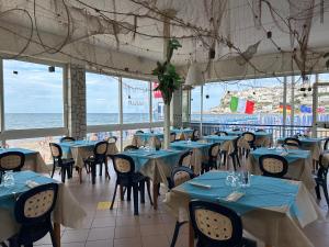 een restaurant met blauwe tafels en stoelen en de oceaan bij Villa Ialillo in Peschici