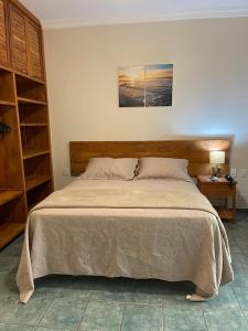 um quarto com uma cama grande e uma cabeceira em madeira em Suite 4101 Ilhaflat em Ilhabela