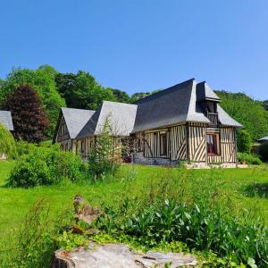 uma grande casa de madeira num campo de relva em L'Herbe Haute em Honfleur