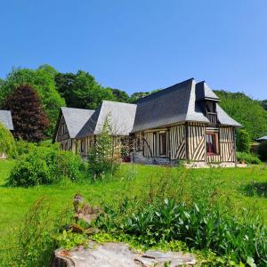 a large wooden house in a field of grass at L'Herbe Haute in Honfleur