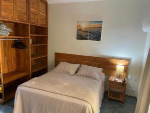 um quarto com uma cama e uma mesa com um candeeiro em Suite 4101 Ilhaflat em Ilhabela