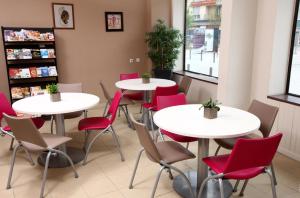 una fila de mesas y sillas en una sala de espera en Hotel Bains Sarrailh, en Dax