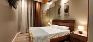 a bedroom with a large bed and two lamps at A&A Luxury Apartments Preveza in Preveza