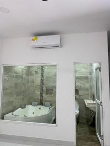 a bathroom with a tub and a toilet and a mirror at APARTAMENTO DORADAL in Doradal