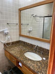 uma casa de banho com um lavatório e um espelho em Suite 4101 Ilhaflat em Ilhabela