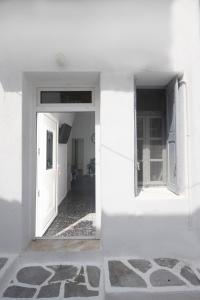 um quarto branco com uma porta branca e um corredor em MATEOS APARTMENT WINDMILLS TOWN em Míconos