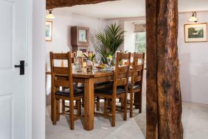 a dining room with a wooden table and chairs at The Snuggery a Cosy Country Cottage in Wellington