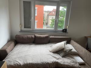 un sofá en una sala de estar con ventana en Mely Rose, en Liubliana