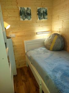 a bedroom with a bed in a wooden cabin at Domus Mare domek holenderski in Wisełka