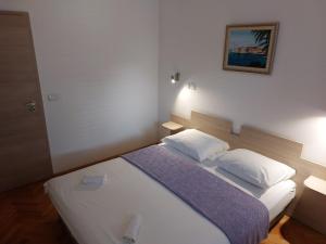 a bedroom with a bed with two pillows at Apartment AB Batala in Dubrovnik