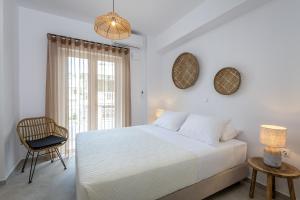 ein Schlafzimmer mit einem Bett, einem Stuhl und einem Fenster in der Unterkunft Suites 33 in Kos-Stadt