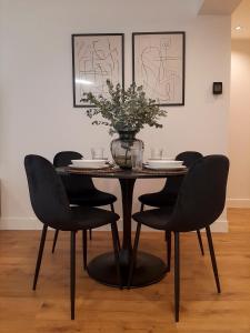 a dining room table with chairs and a vase of flowers at Apartamento Nordeste in Gijón +13 photos