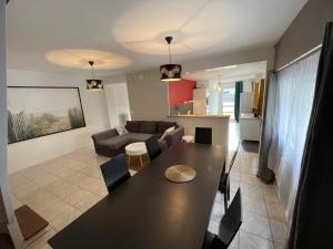a living room with a table and a couch at Maison centre bourg à 50m de la plage in Cherrueix