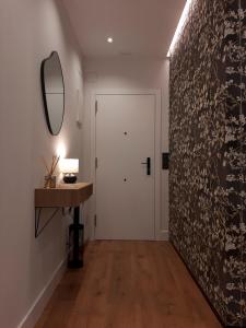 un corridoio con porta bianca e specchio di Apartamento Nordeste a Gijón