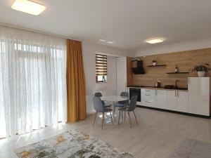 a kitchen and dining room with a table and chairs at Apartament Genius 2 in Ploieşti