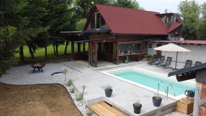 a house with a swimming pool in front of a house at Lake House with a View in Šmartno v Rožni Dolini