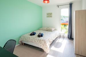 a bedroom with a bed with shoes on it at Tranquillité assurée in Évreux