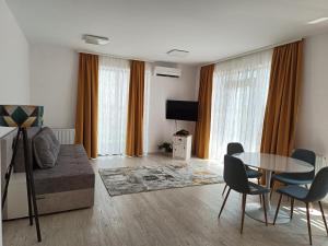 a living room with a table and chairs at Apartament Genius 2 in Ploieşti