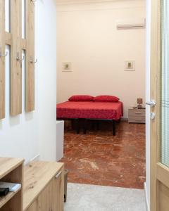 a bedroom with a red bed in a room at Nopal casa vacanze in San Vito dei Normanni