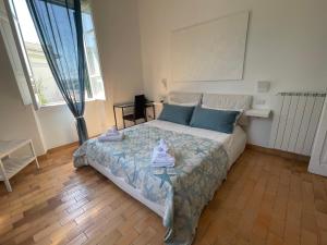 1 dormitorio con 1 cama grande con almohadas azules en La terrazza sul mare, en Santa Marinella
