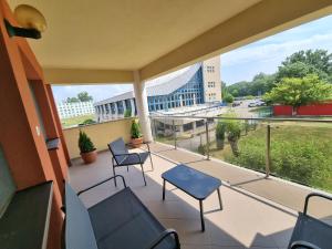 d'un balcon avec des chaises et une vue sur un bâtiment. dans l'établissement Bougainvillea Apartman, à Sfântu-Gheorghe