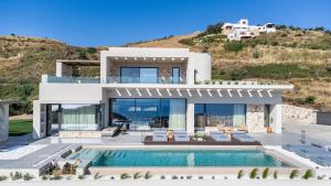 a villa with a swimming pool and a house at Villa 7 Seas - With Amazing View in Lefkogeia