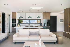 sala de estar con sofá y cocina en Villa 7 Seas - With Amazing View, en Lefkogeia