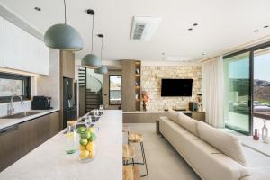 una cucina e un soggiorno con divano e tavolo di Villa 7 Seas - With Amazing View a Lefkogeia