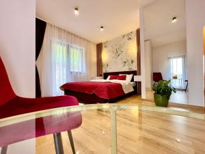 a bedroom with a red bed and a red chair at Casa Fratila in Holbav +128 photos