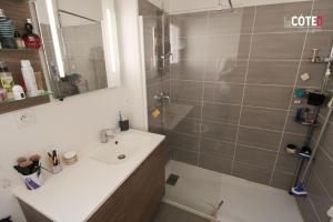 een badkamer met een douche, een wastafel en een spiegel bij Jardin de Lucien - T3 en duplex in Châteauneuf-lès-Martigues