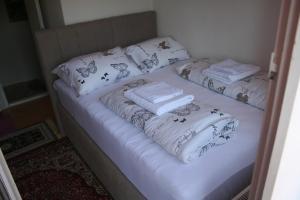 2 Betten mit weißen Decken und Handtüchern darauf in der Unterkunft Michaela in Gračac