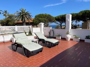 a patio with two lounge chairs on a brick patio at La terrazza sul mare in Santa Marinella