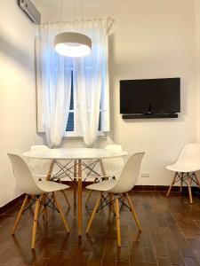 - une salle à manger avec une table, des chaises et une télévision dans l'établissement La terrazza sul mare, à Santa Marinella