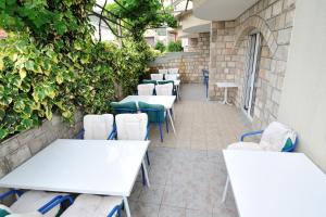 - une rangée de tables et de chaises sur la terrasse dans l'établissement Hotel Lav, à Neum
